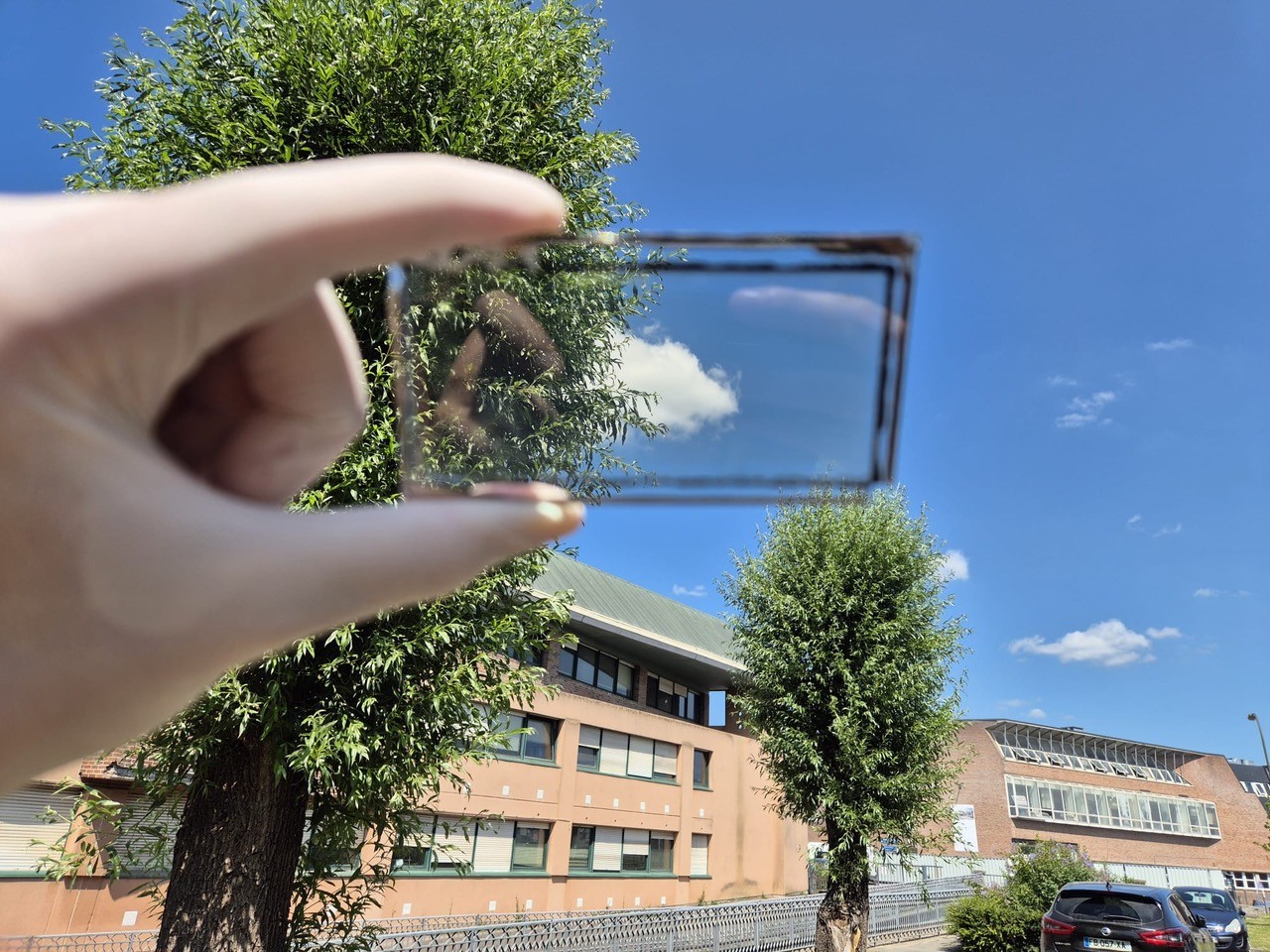verre électrogène tenu dans une main en direction du ciel.